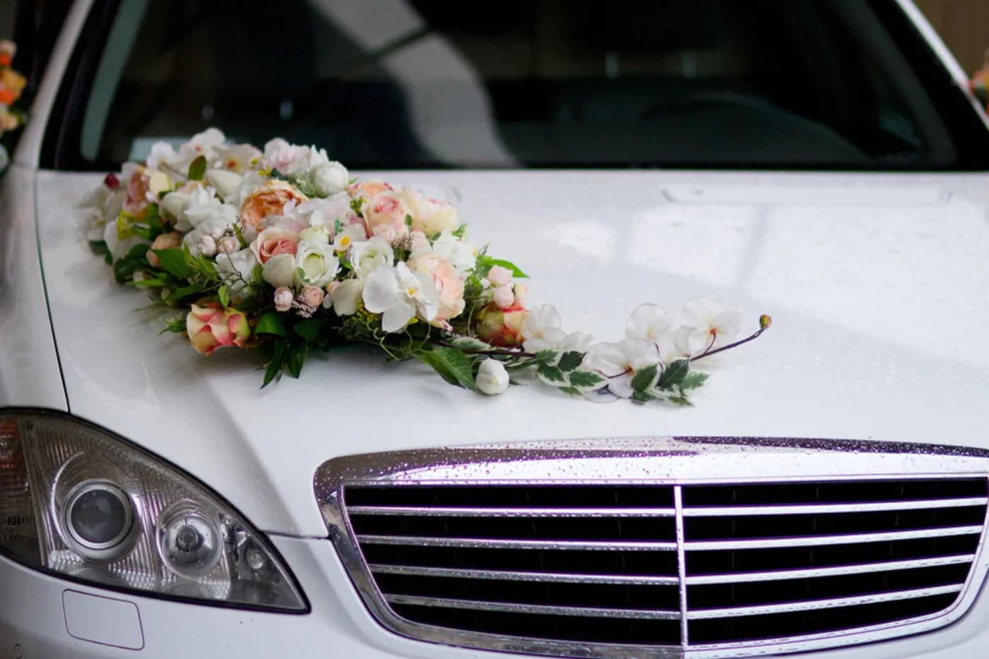 White Mercedes bonnet decorated with an ivory and pink floral arrangement