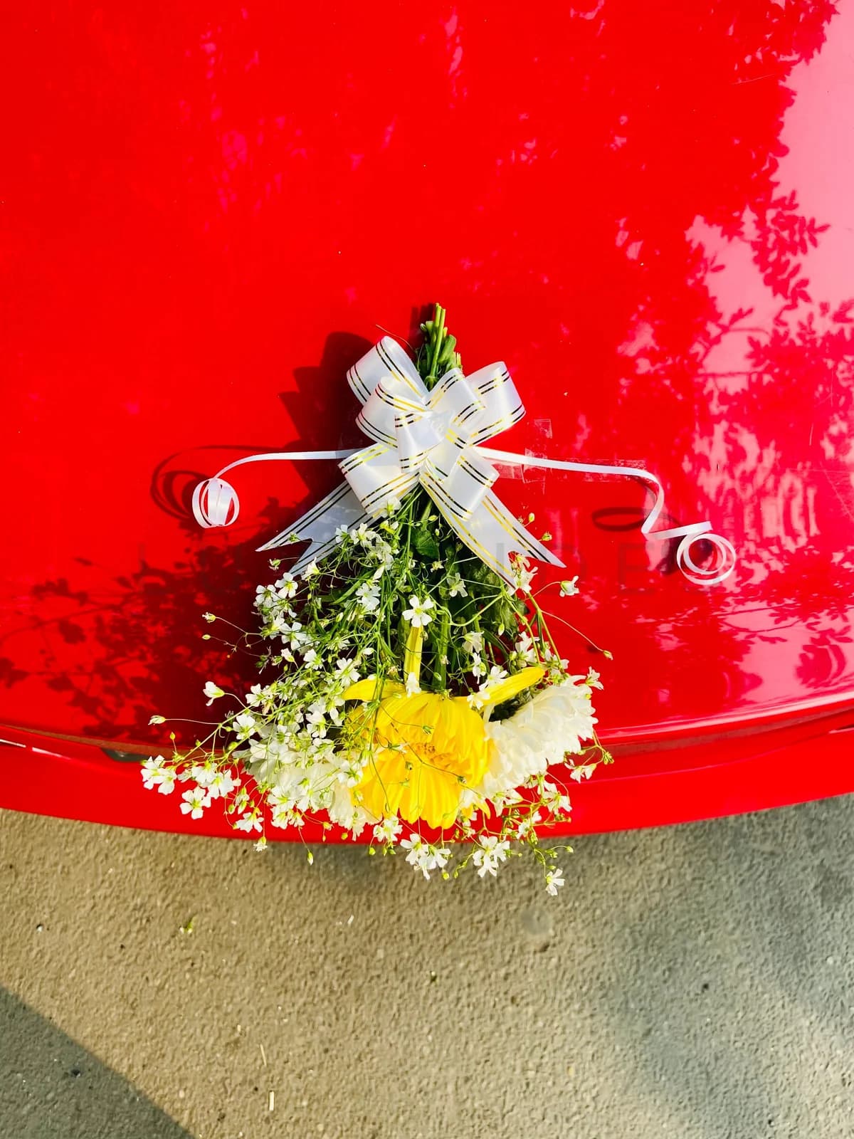 Small floral arrangement on a red Mercedes-Benz CLA