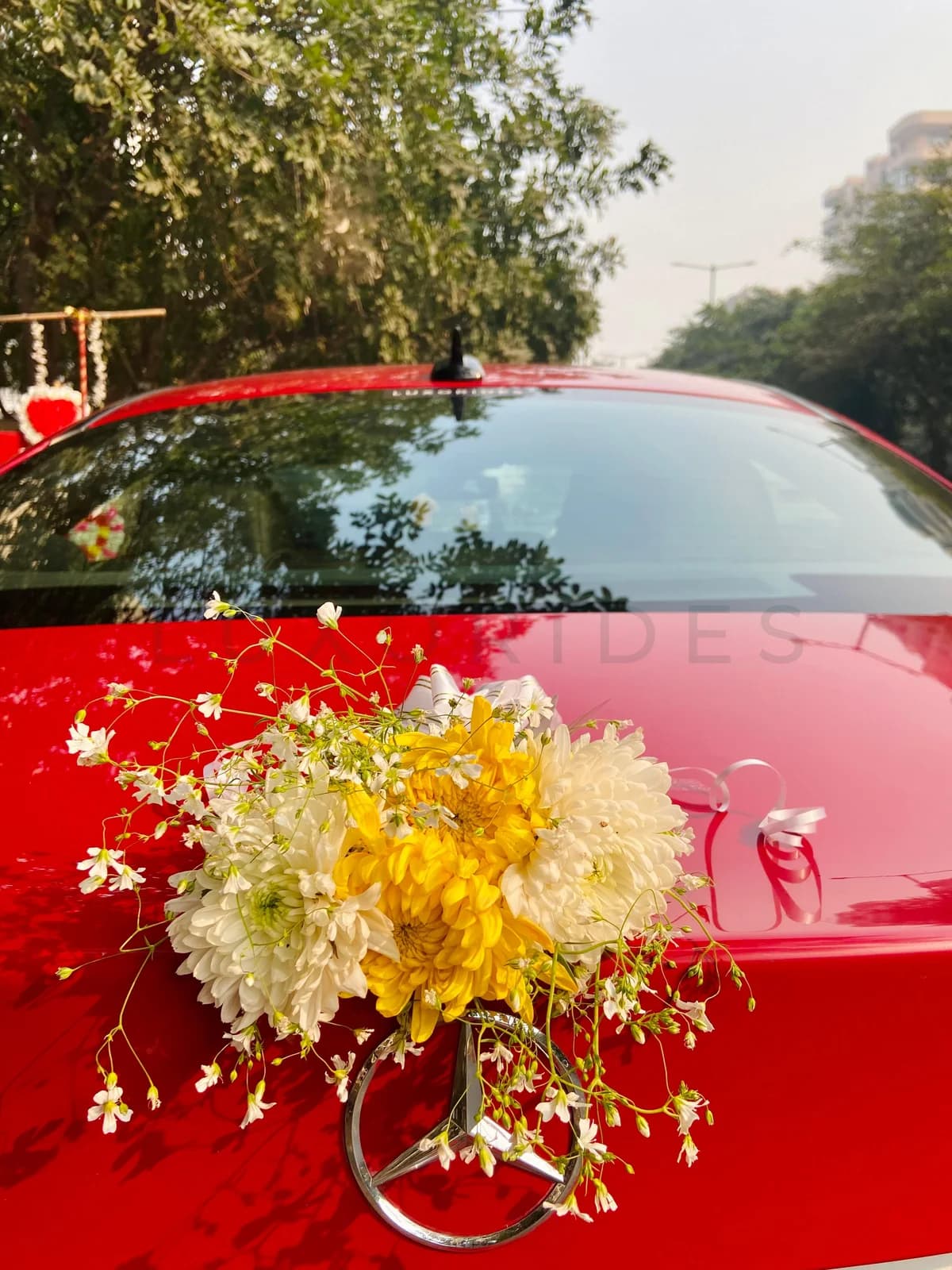 Red Mercedes-Benz CLA with wedding flowers and ribbons