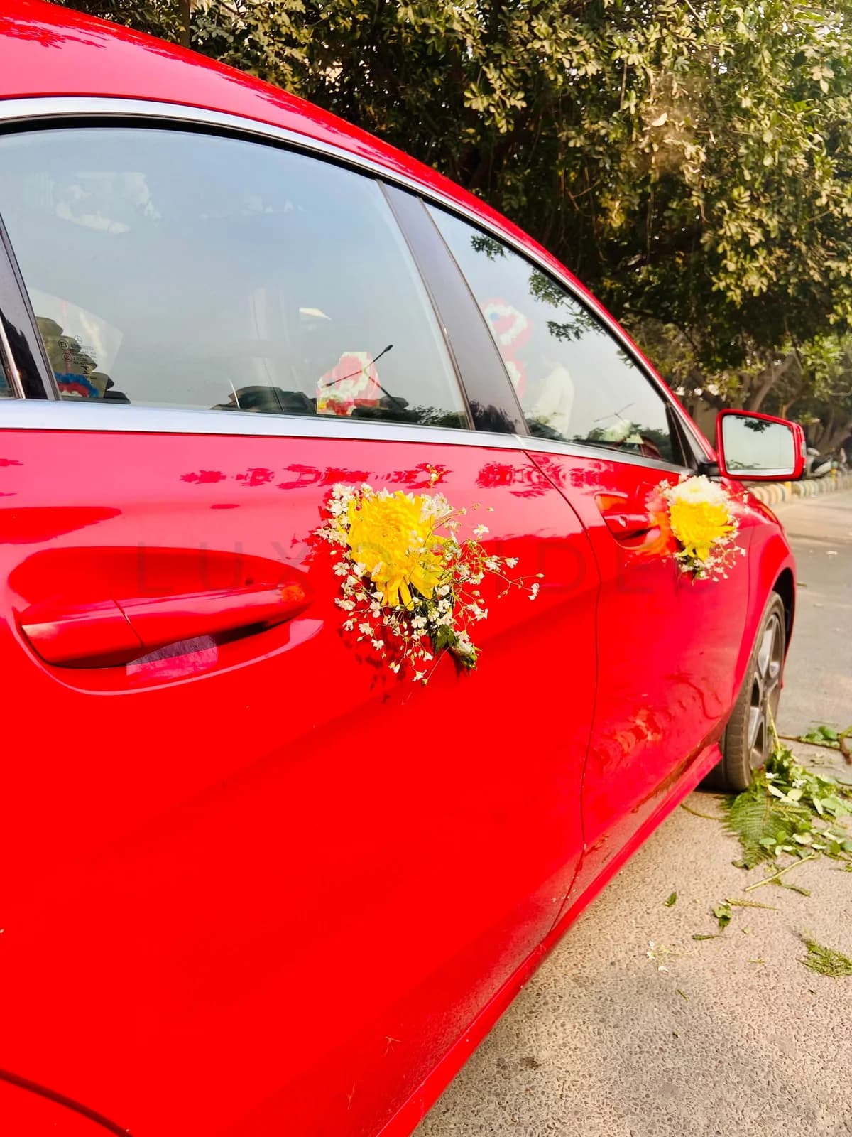 Red Mercedes-Benz CLA doors decorated with yellow and white flowers