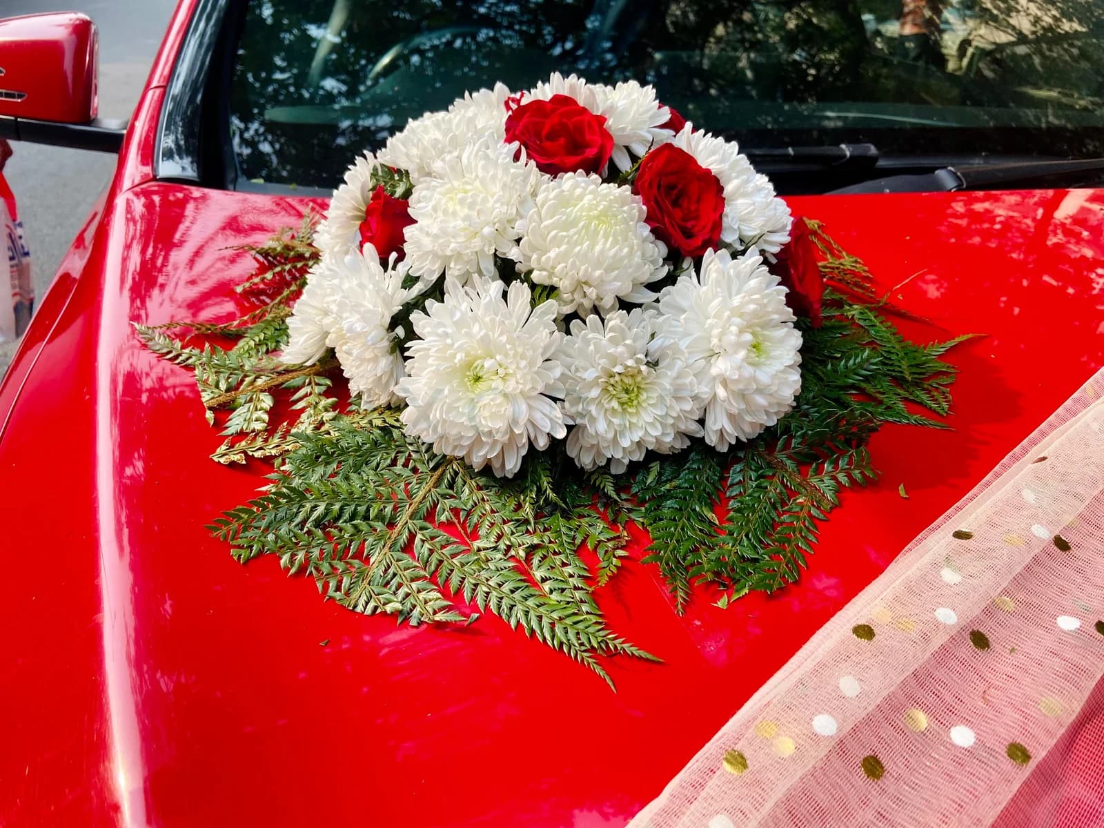 Red and white floral bouquet on a red Mercedes-Benz CLA