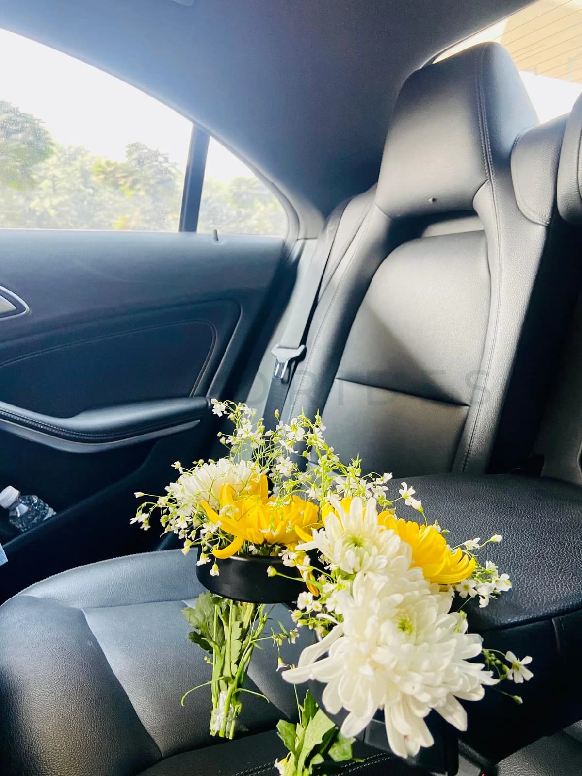 Yellow and white bouquet on the rear seat of a Mercedes-Benz CLA