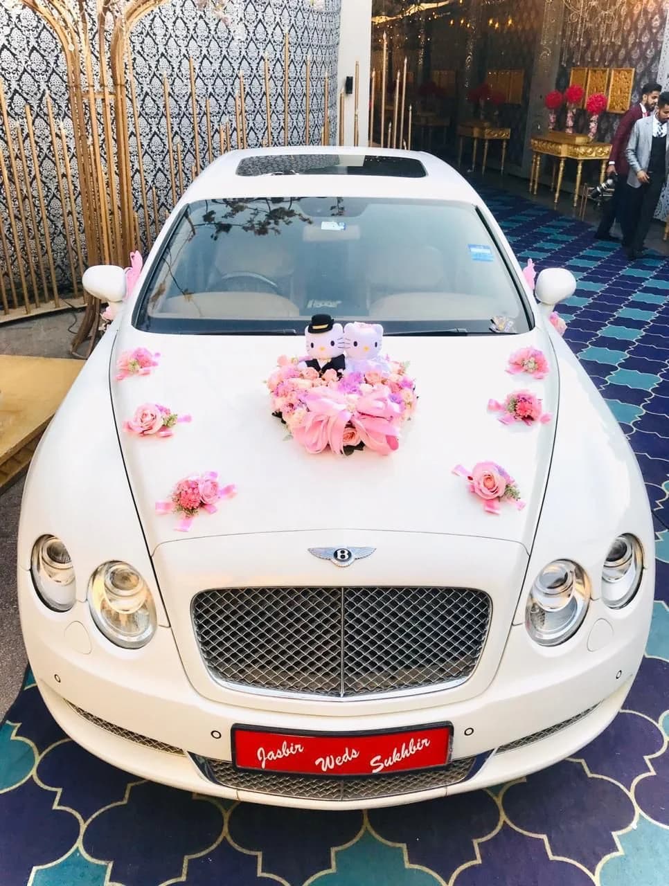 White Bentley with pink flowers and a personalised wedding plate