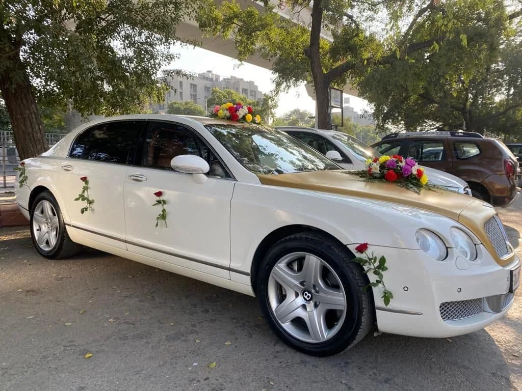 White and gold Bentley with roses attached to its doors