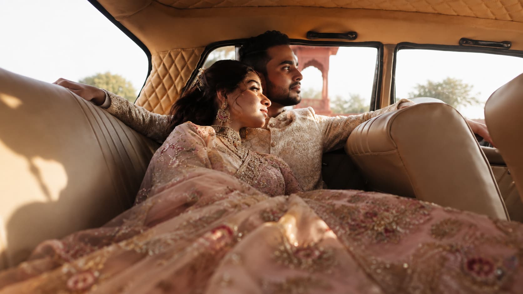 Wedding couple relaxing together inside a vintage car