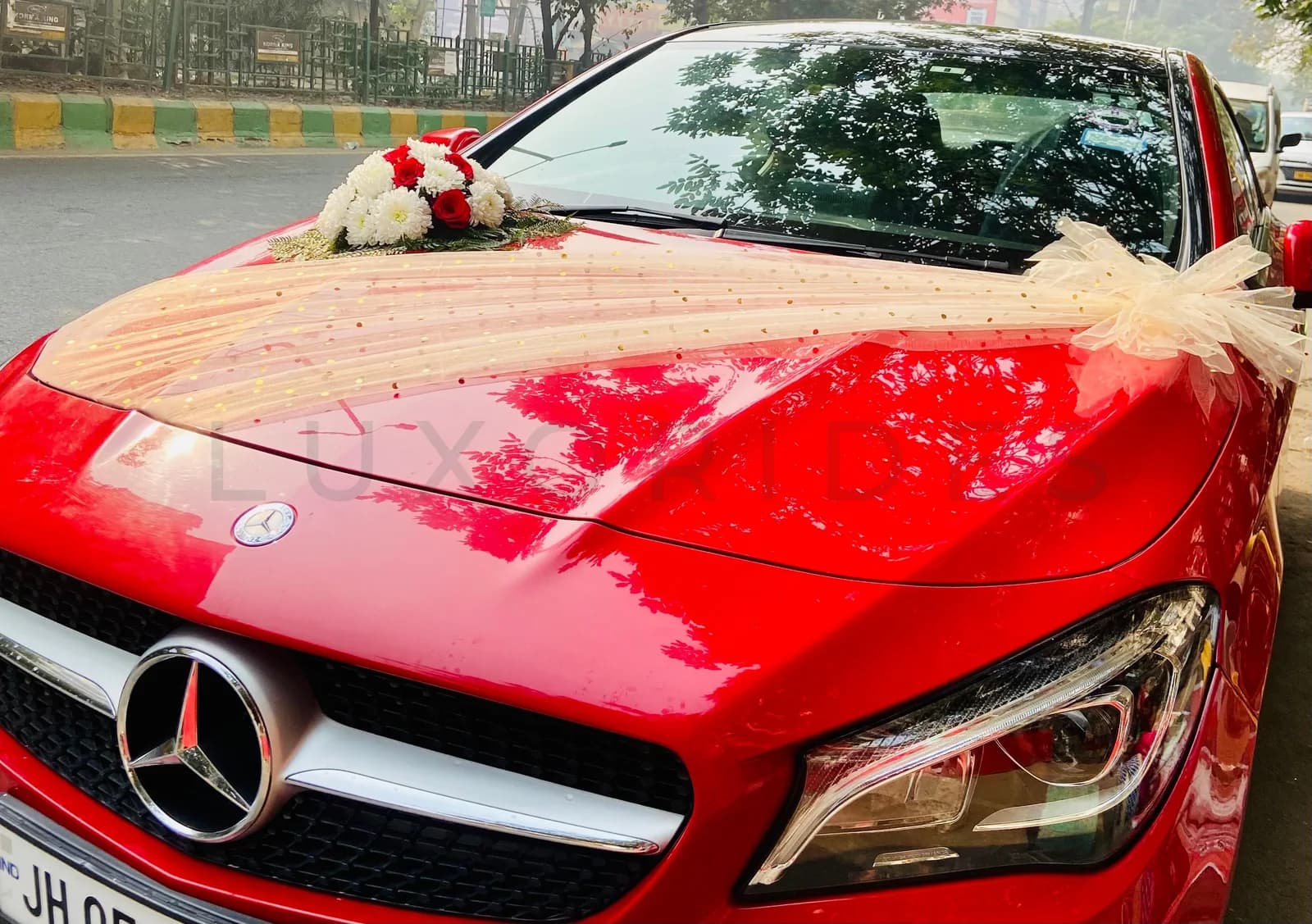 Red Mercedes-Benz CLA with ivory fabric and floral wedding decorations